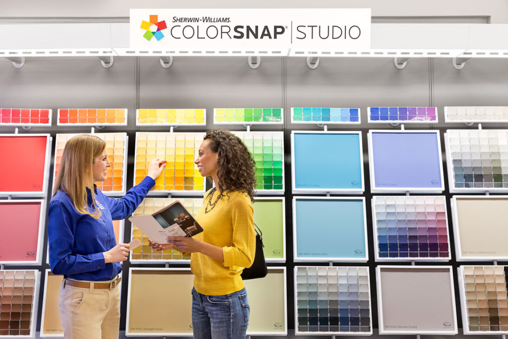 two women next to color swatches in hardware store