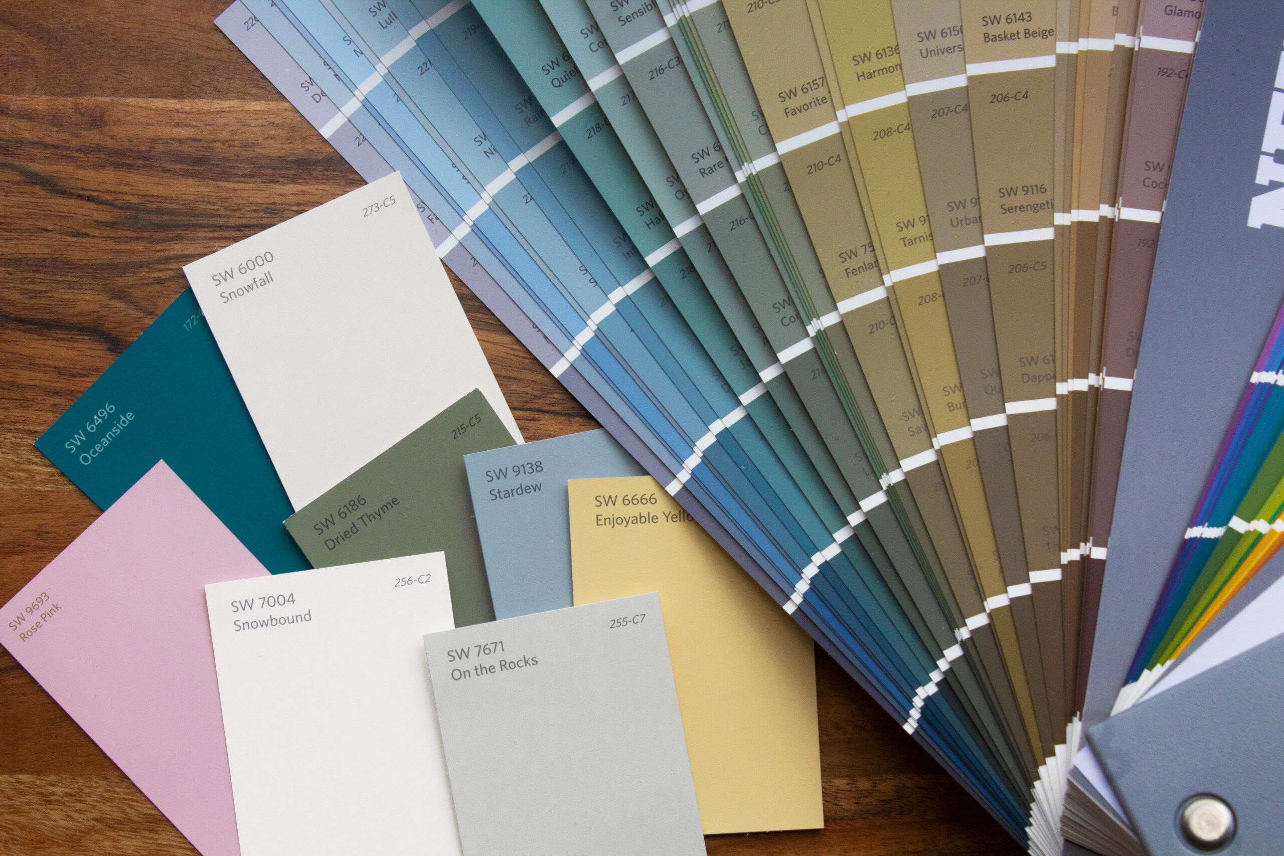A Sherwin-Williams paint strip fan deck next to individual color chips.