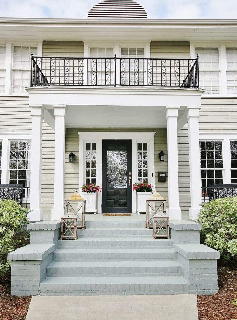 Exterior of a traditional-style house with painted brick steps and front porch.