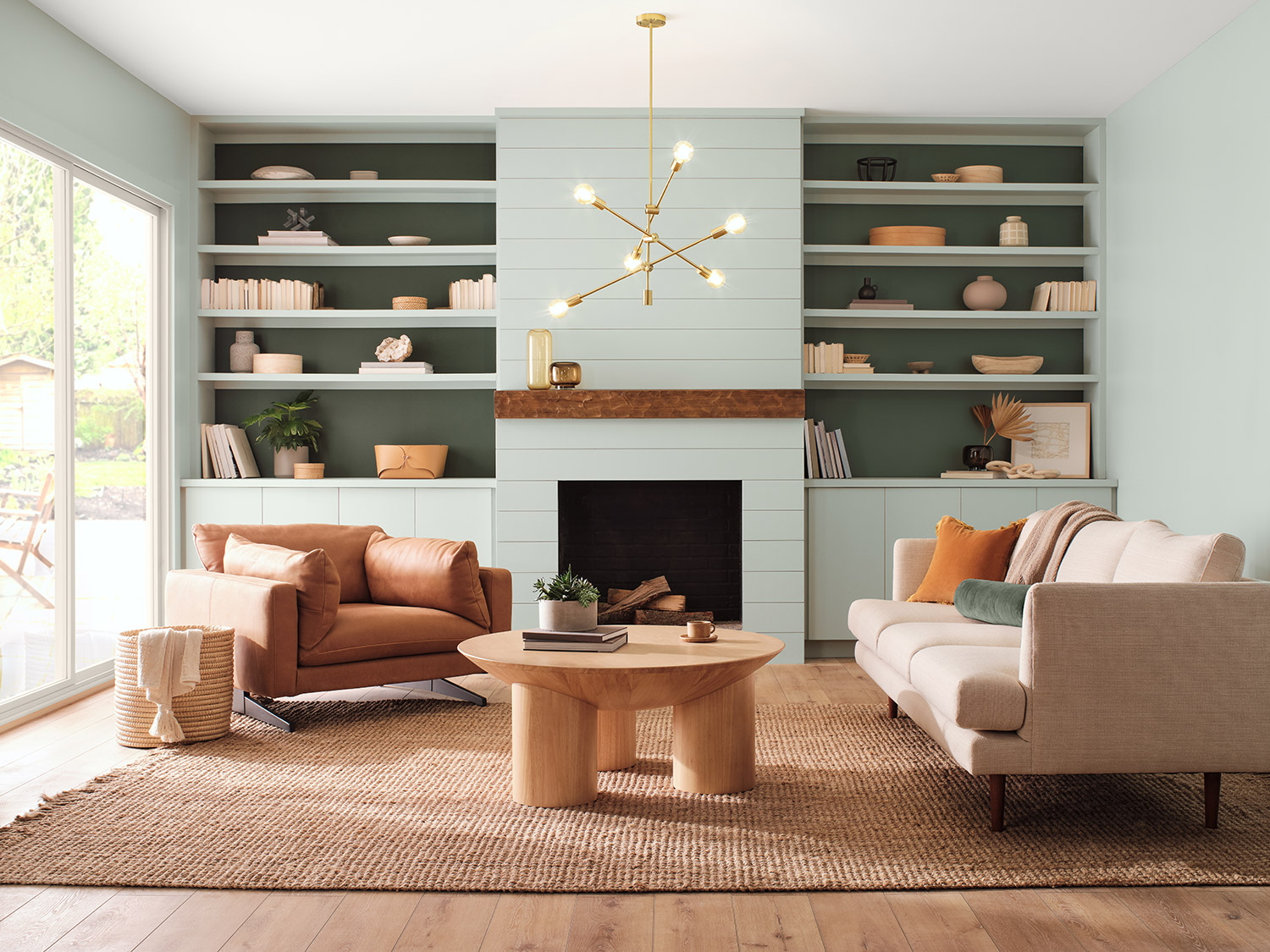 Modern living room with built in shelves framing a fireplace, beige and brown couches, and minimalist decorations. Walls and Shelves painted Copen Blue SW 0068