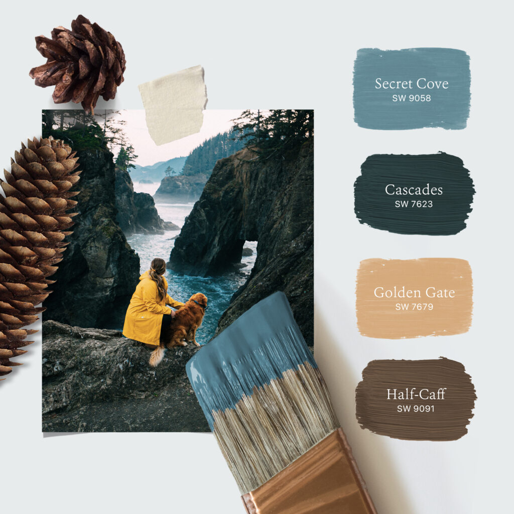 Photo of a woman in a yellow raincoat petting her dog and gazing out over rugged cliffs along a foggy ocean shoreline. Laying on the photo are two pinecones and a paint brush dipped in blue-colored paint. To the right of the photo is a stacked palette of four Sherwin-Williams paint colors including Secret Cove SW 9058, Cascades SW 7623, Golden Gate SW 7679, and Half-Caff SW 9091.