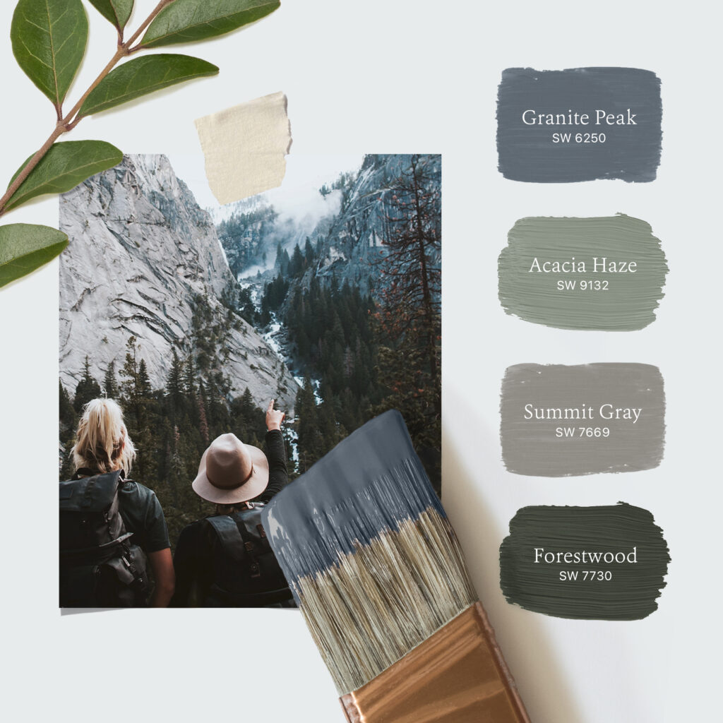 Photo of two people standing side by side admiring the scenery of the Rocky Mountains. Laying on the photo is a leafy branch and a paint brush dipped in blue-colored paint. To the right of the photo is a stacked palette of four Sherwin-Williams paint colors including Granite Peak SW 6250, Acacia Haze SW 9132, Summit Gray SW 7669, Forestwood SW 7730.