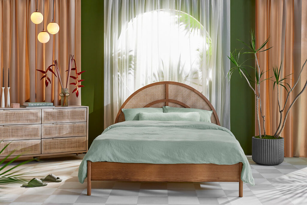 bohemian bedroom featuring green walls and a bed with a curved headboard