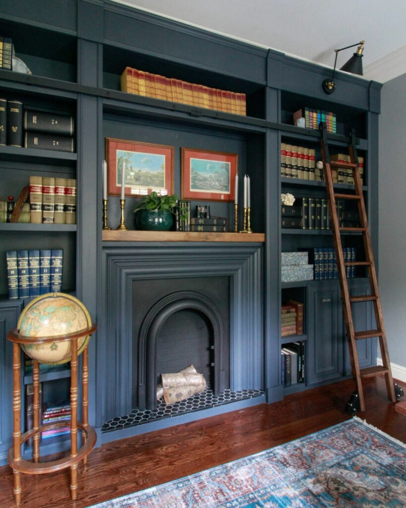 Home library with floor-to-ceiling bookshelves and a faux fireplace.