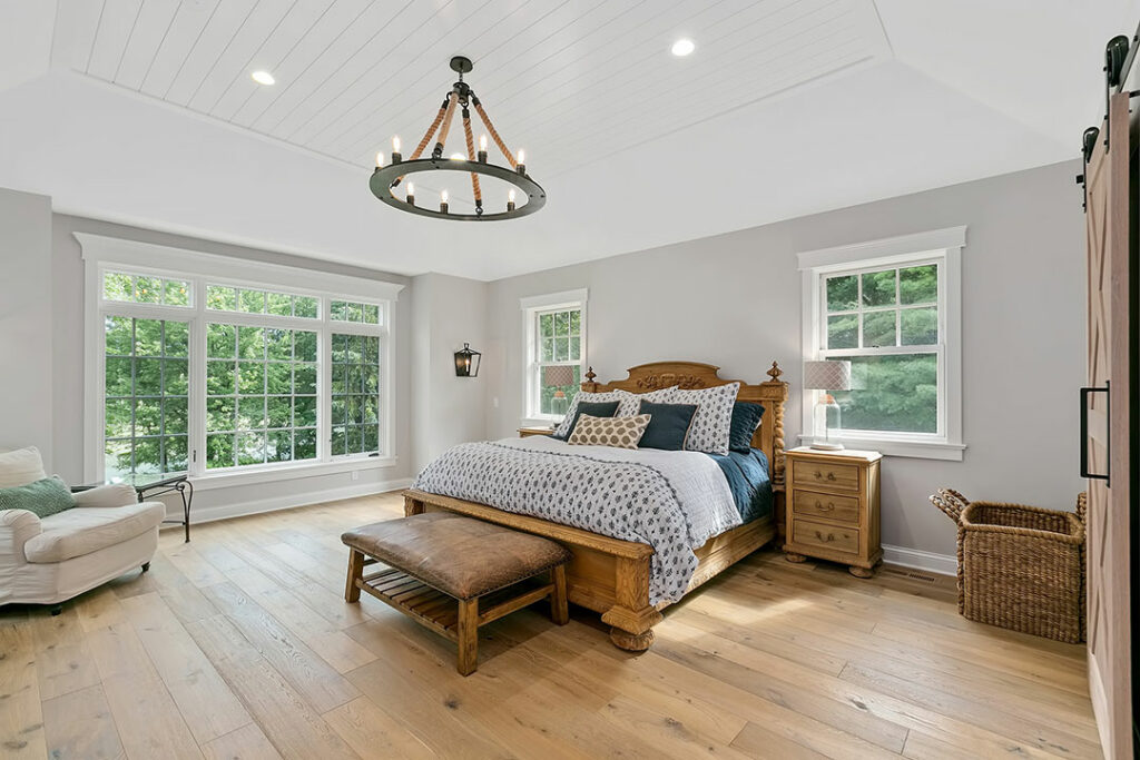 wide shot of a bedroom with gray walls and lots of natural light.