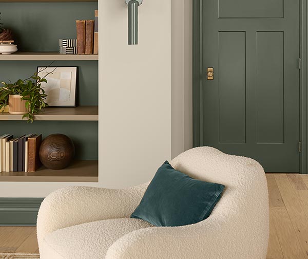 A fluffy white chair in front of a door painted Rosemary SW 6187.