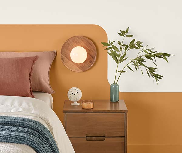 Cropped photo of a bed with a night stand and pendant light.