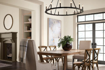 Dining room scene with a rustic wooden table in the center. Natural light pours in from the glass French-doors behind the table. Walls are painted in Kestrel White with trim in Dhurrie Beige.