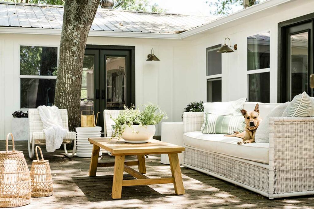 Deck space with a cozy couch and a dog lounging in the comfort.