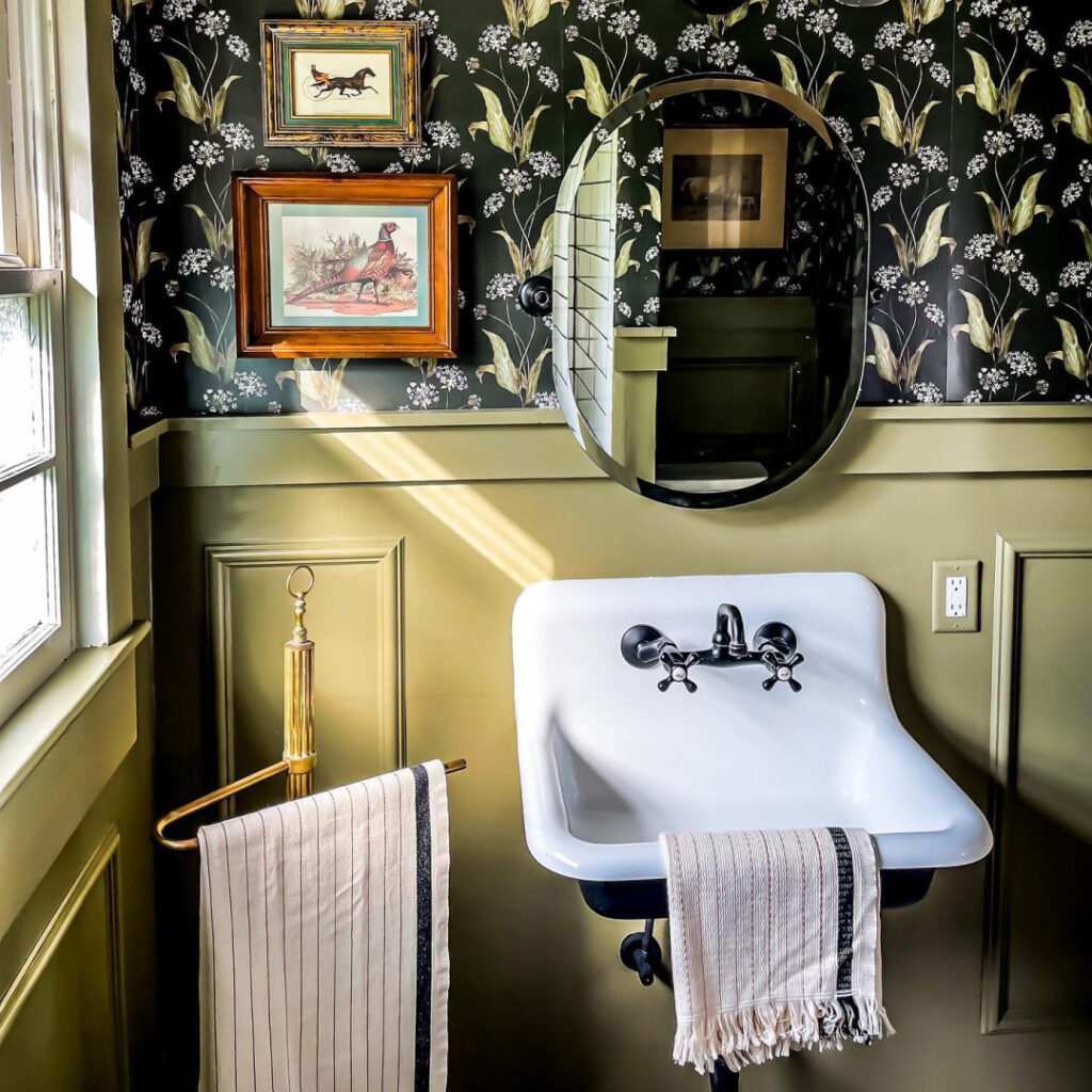 Bathroom sink with dark floral wallpaper coordinated with wainscoting painted in Messenger Bag SW 7740.