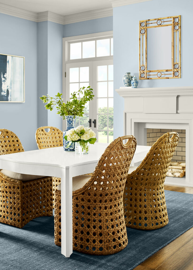 Dining room scene with high-back wicker chairs and walls painted in Upward SW 6239.