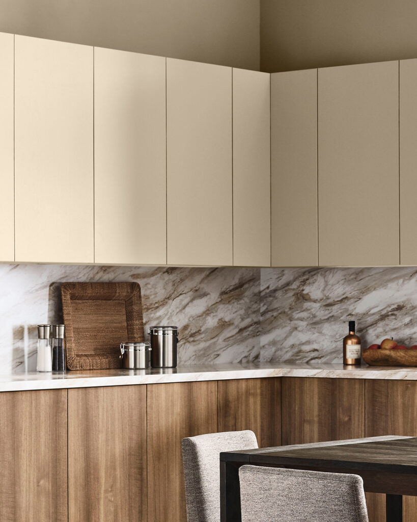 Kitchen scene with marble backsplash and upper cabinets painted in Universal Khaki with wood finish lower cabinets.