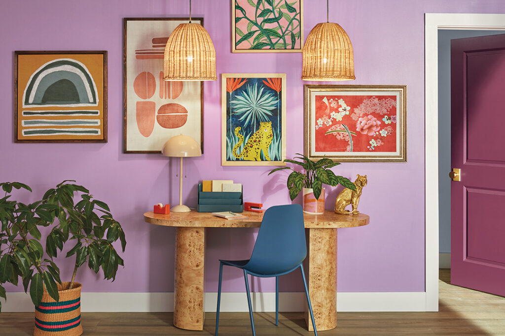 Maximalist-inspired sitting area with a desk and chair and wall painted in Novel Lilac SW 6836 and door in Juneberry SW 6573.